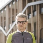 Mountain biking in South Tyrol © Hannes Niederkofler Older man in cycling gear holding helmet near a modern building