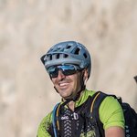 Mountain biking in South Tyrol © Harald Wisthaler Man with mountain bike and helmet sitting on grass with mountains behind