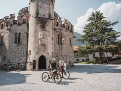 Bressanone © Brixen Tourismus - Hannes Engl Two cyclists in front of a historic stone tower on a sunny day