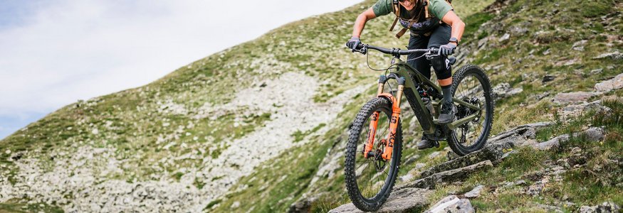 Mountainbiker fährt auf felsigem Bergpfad talwärts