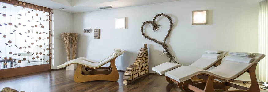 Ruheraum mit modernen Liegestühlen und Holzstapeln an der Wand