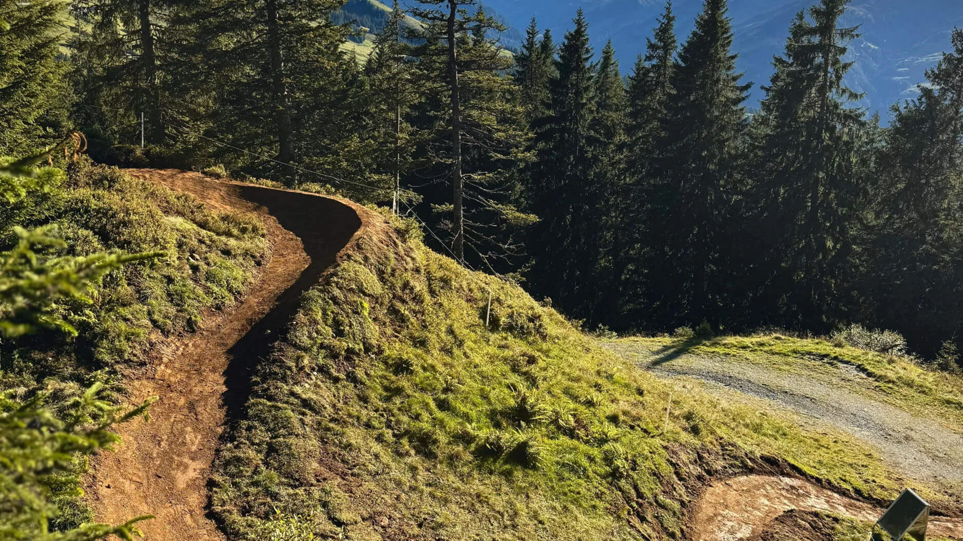 Neuer Flow im Brixental: Der Kirchberg Trail eröffnet © TVB Kitzbüheler Alpen - Brixental - Allegra Wanderweg durch bewaldete Berge mit klar blauem Himmel und Wolken