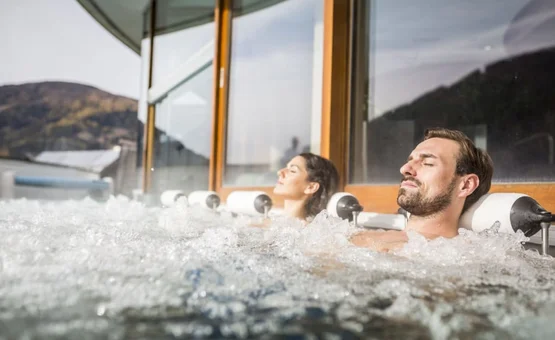 Ski & Wellness - 3 nights Man and woman relaxing in a hot tub with mountain view