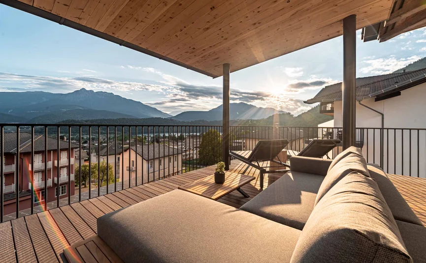 Terrace with sofa, loungers, and mountain view at sunset