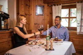 Winemaker on the mountain summer & autmun - 2 nights Couple toasting with red wine in cozy wooden-walled restaurant