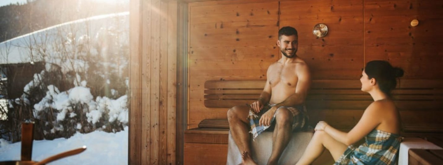 Stel ontspant in sauna met uitzicht op besneeuwde bergen