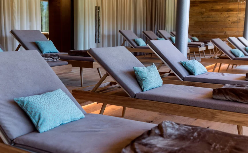 Empty lounge chairs with blue pillows in a cozy spa room
