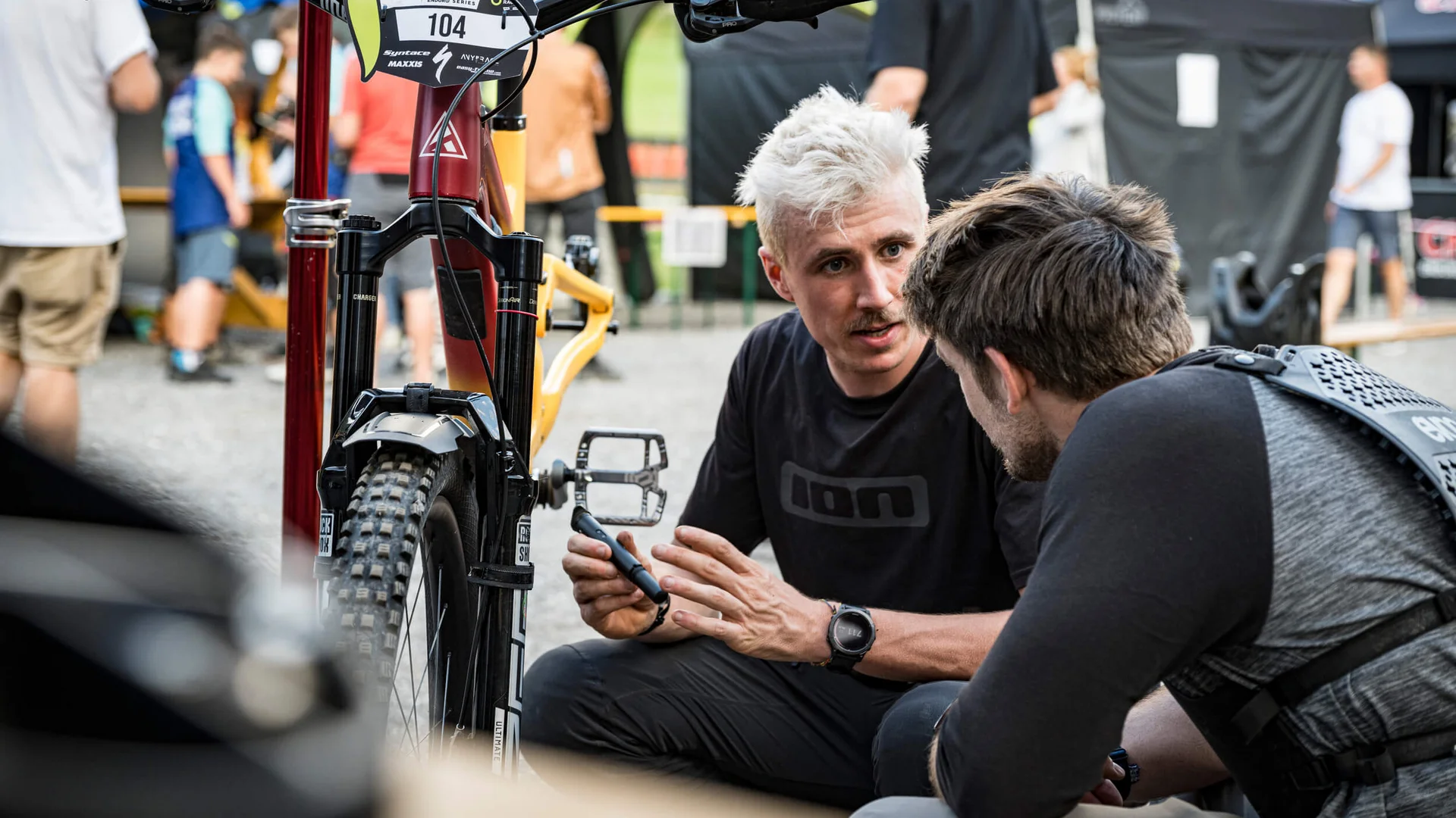 Zwei Männer besprechen Mountainbike vor Rennen