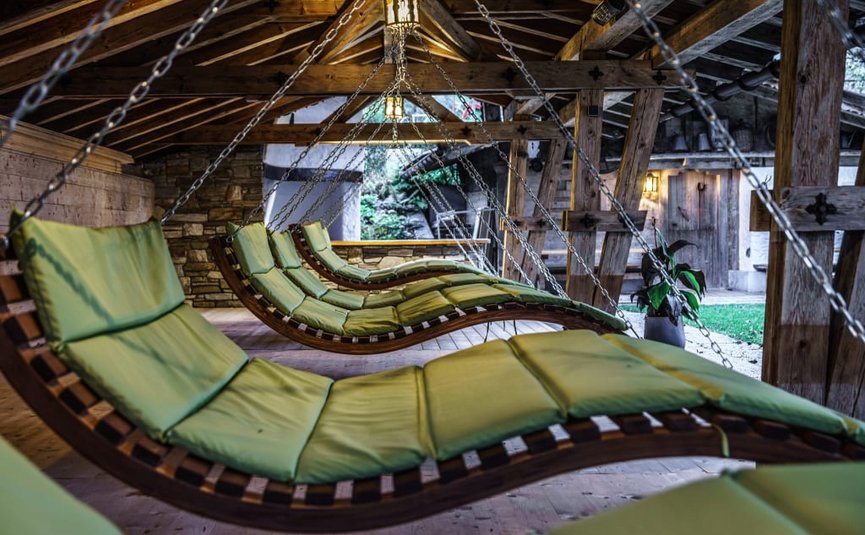 Activity holidays Hanging green cushioned loungers inside a wooden cabin