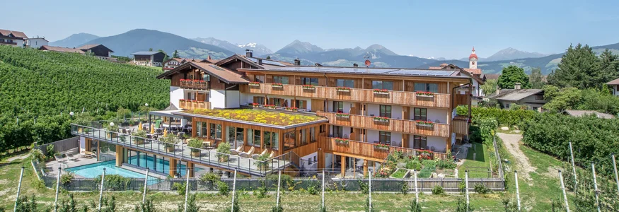 Hotel vor Weinbergen mit Bergpanorama und blauem Himmel