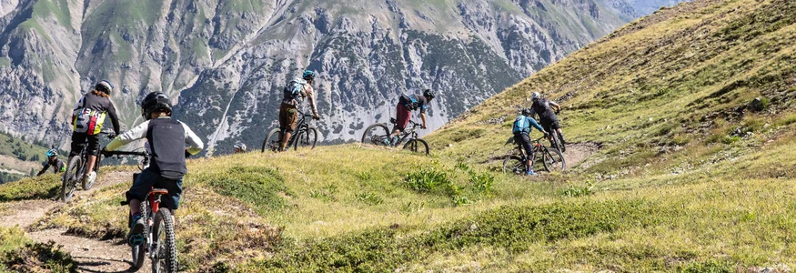 Livigno © Samuel Confortola Groep mountainbikers op een pad in een alpenlandschap