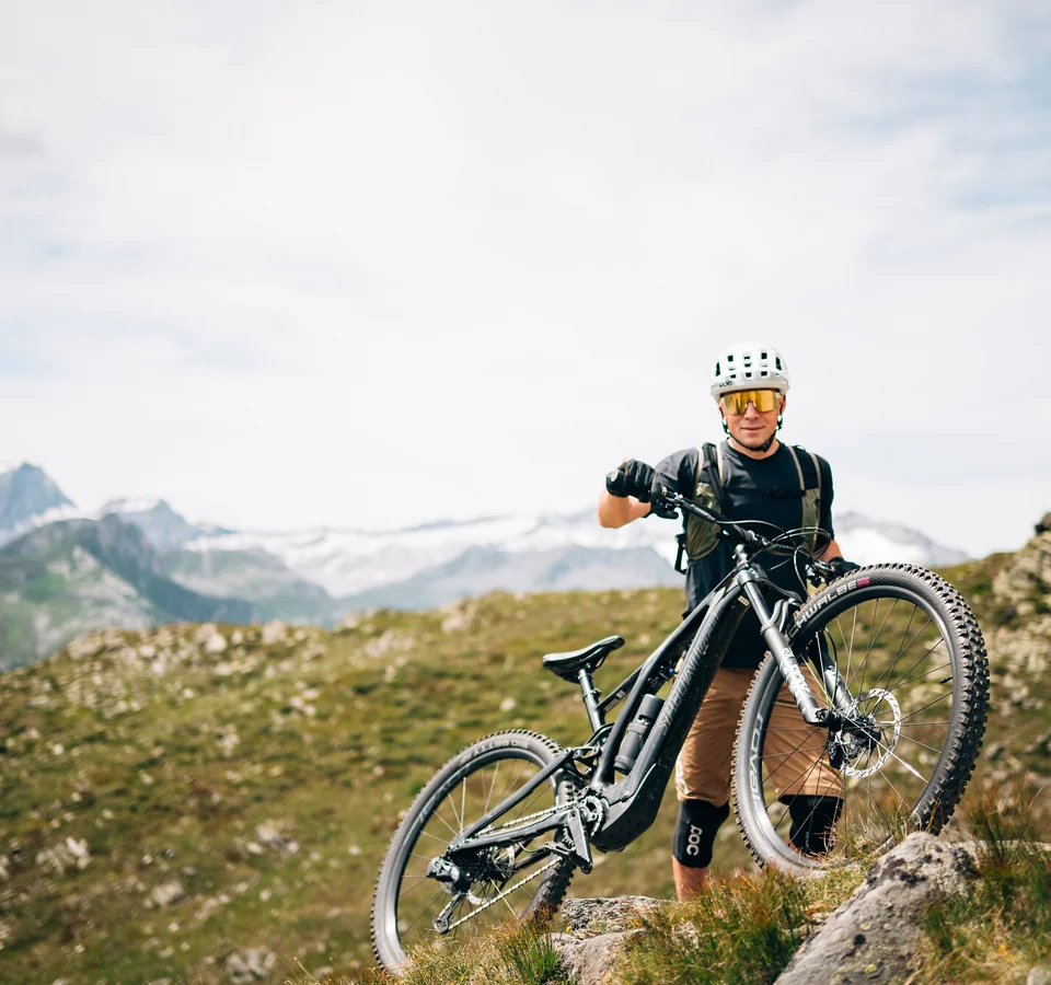 Auf Trail-Mission im Ahrntal © Martina Wunderle Mountainbiker mit Helm steht auf Felsen in bergiger Landschaft