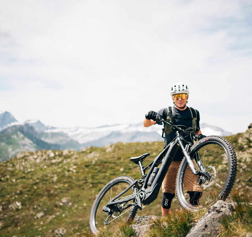 Auf Trail-Mission im Ahrntal © Martina Wunderle Mountainbiker mit Helm steht auf Felsen in bergiger Landschaft