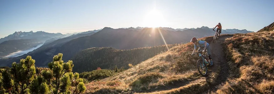 Biken & Genießen im Montanara © Salzburger Sportwelt Altenmarkt Zauchensee Zwei Mountainbiker auf einem sonnigen Bergtrail mit Alpenpanorama