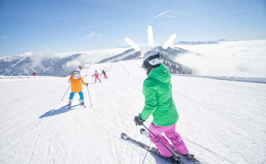 Skiing on snowy mountain with clear sky and clouds