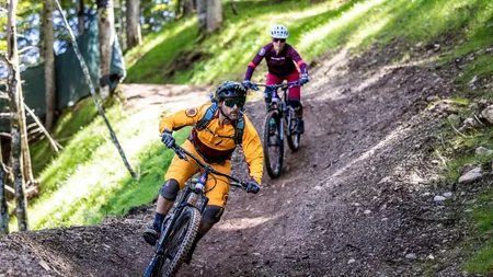 Unterwegs in Österreichs größter Bikeregion © Klemens König Zwei Mountainbiker fahren auf einem Waldpfad bergab