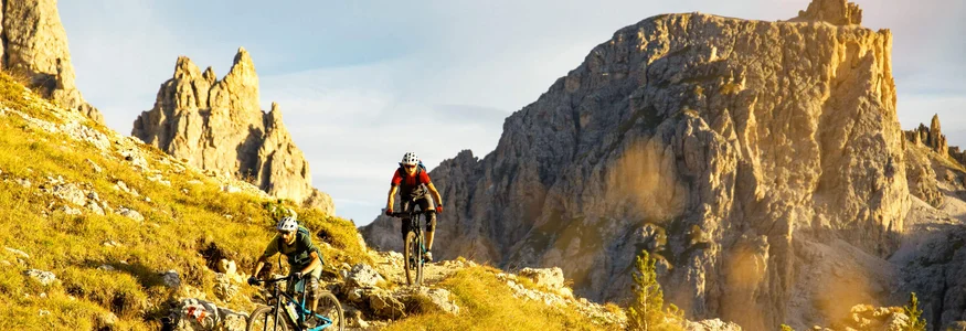 Zwei Mountainbiker auf einem Bergpfad in sonniger Gebirgslandschaft