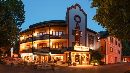 Bike Boutique Hotel Lindenhof Illuminated hotel building with balconies and outdoor seating in the evening