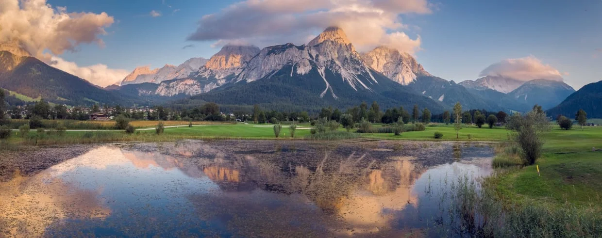 Mountain panorama with clouds and lake reflection