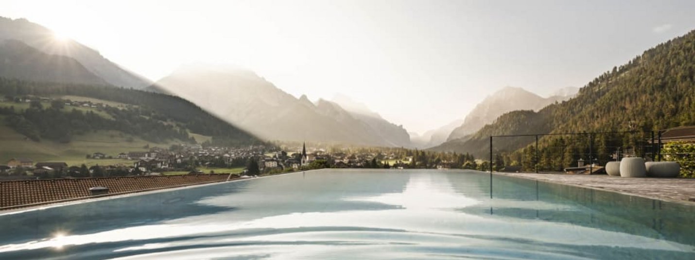 Infinity pool overlooking valley and mountains at sunset