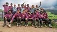 Gruppenfoto von Mountainbikern in Schutzkleidung und Trikots in einer Berglandschaft