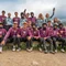 Gruppenfoto von Mountainbikern in Schutzkleidung und Trikots in einer Berglandschaft