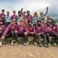 Gruppenfoto von Mountainbikern in Schutzkleidung und Trikots in einer Berglandschaft