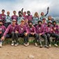 Gruppenfoto von Mountainbikern in Schutzkleidung und Trikots in einer Berglandschaft