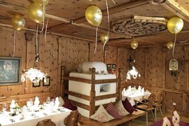 Rustikales Restaurant mit Holzwänden, festlich gedeckte Tische und goldene Luftballons
