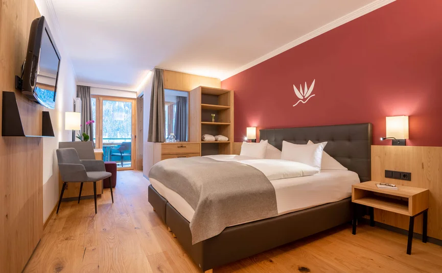 Modernes Hotelzimmer mit Doppelbett, Holzboden und Balkon