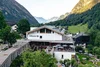 Hotel Walliserhof in einem Bergtal mit Terrasse und Sonnenliegen