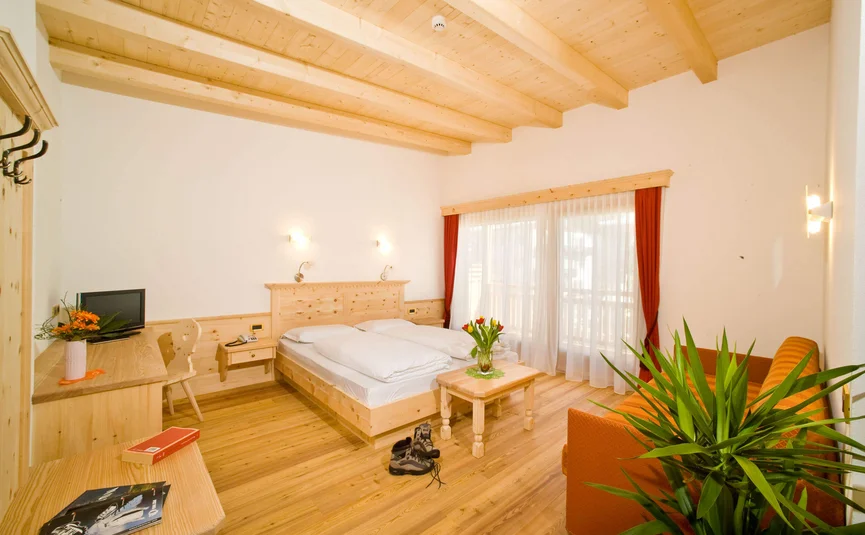 Gemütliches Hotelzimmer mit Holzmöbeln und Balkonfenster