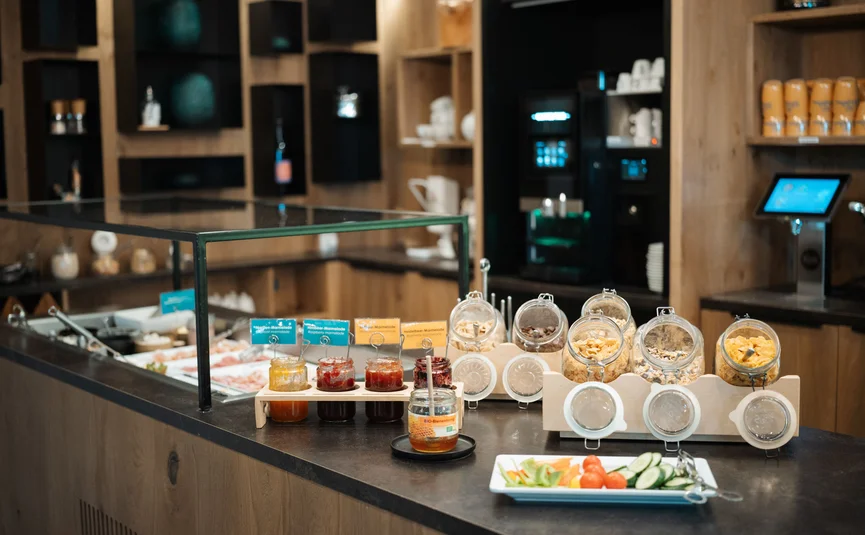 Buffet mit Aufstrichen, Müsli und frischem Gemüse in modernem Selbstbedienungsbereich