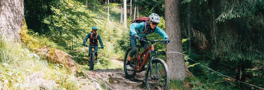 Mountainbike-Urlaub in Tirol © Patrick Wasshuber Zwei Mountainbiker fahren auf einem wurzeligen Waldweg bergab