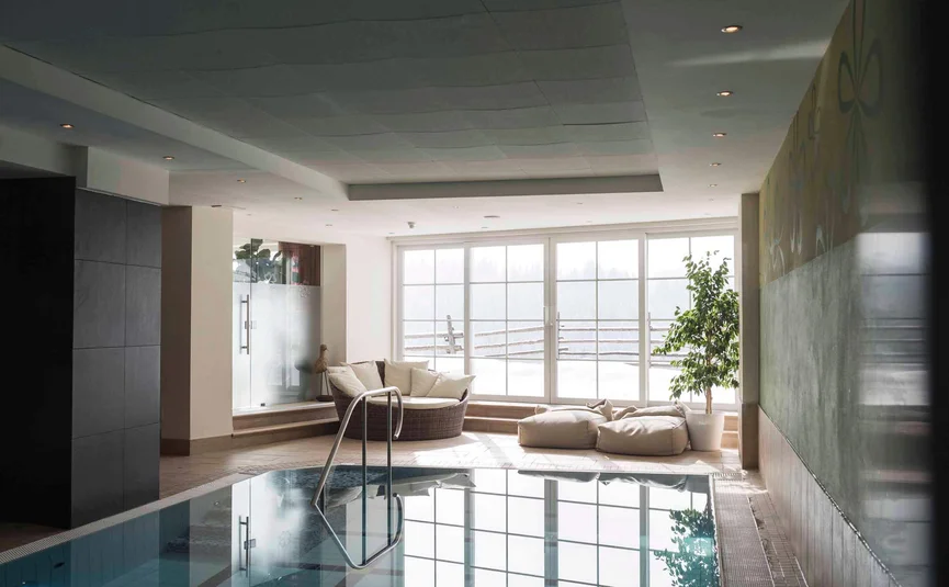 Lichte wellnessruimte met binnenzwembad, zithoek en groot raam