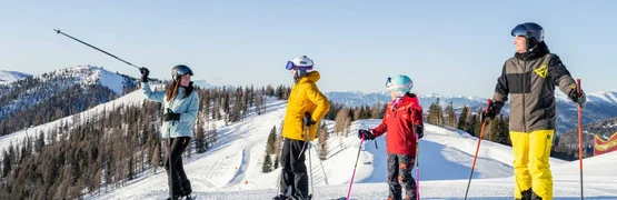 Four skiers on a snowy slope with mountain views