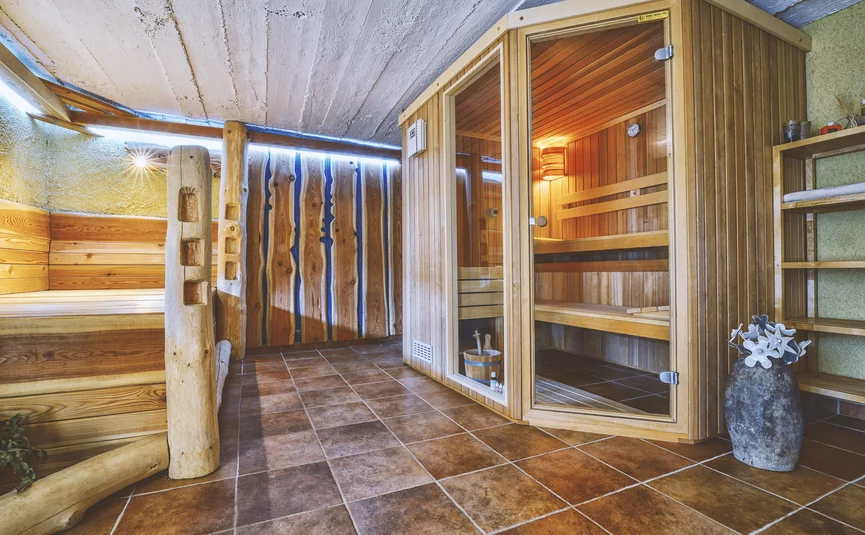Innenraum eines Saunabereichs mit Holzbänken und Holzsauna