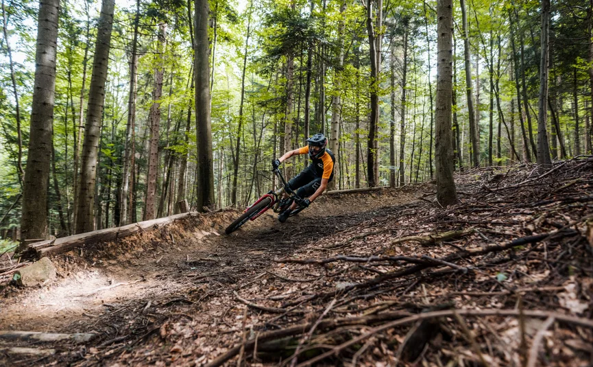 Mountainbiker die snel een bocht neemt op een bospad