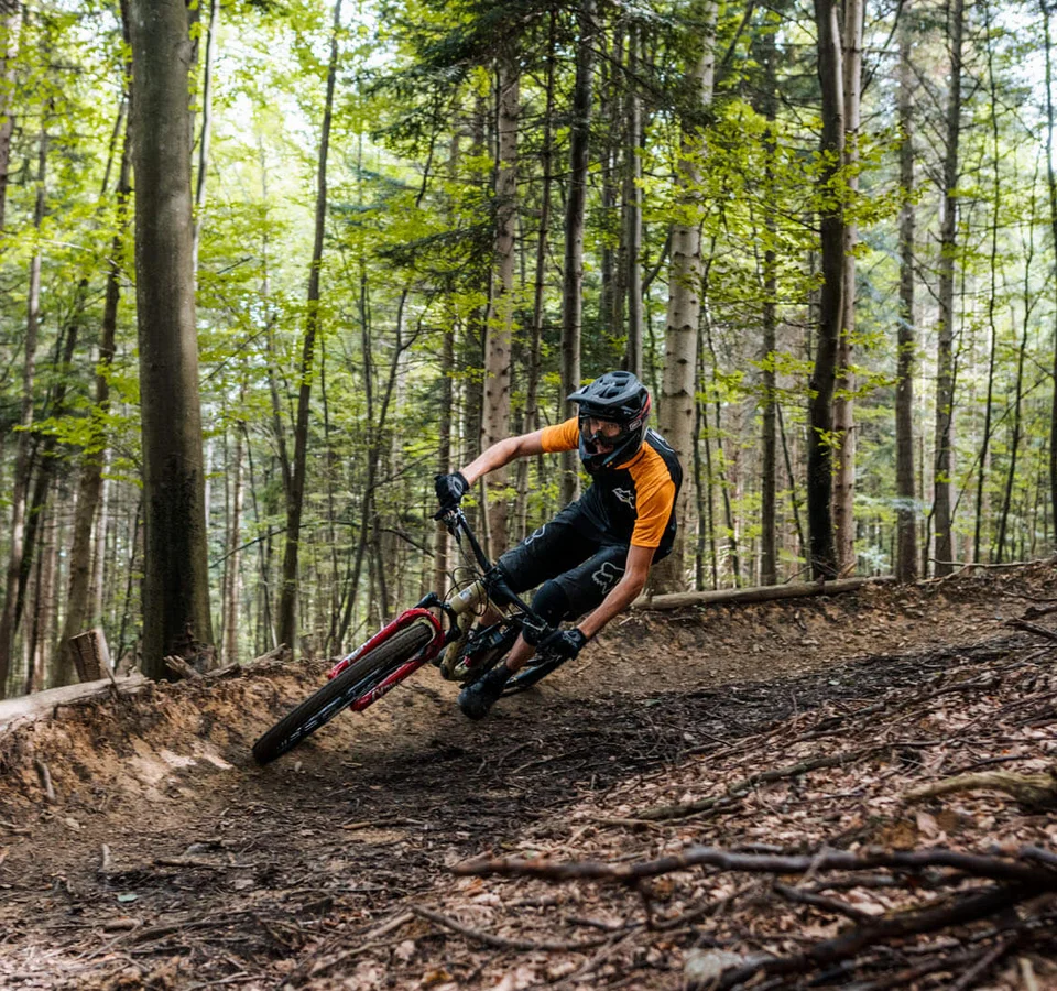 Mountainbiker fährt schnell auf Waldweg um Kurve