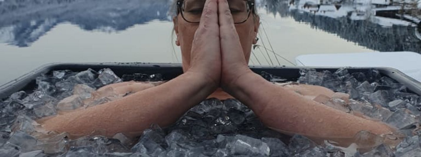 Atmen & Kälte – Das „coole“ Retreat Grundlagen Vrouw ontspant in ijsbad met besneeuwde bergen en meer op achtergrond