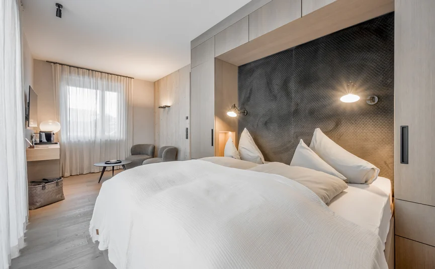 Modernes Schlafzimmer mit großem Bett und Sitzbereich am Fenster