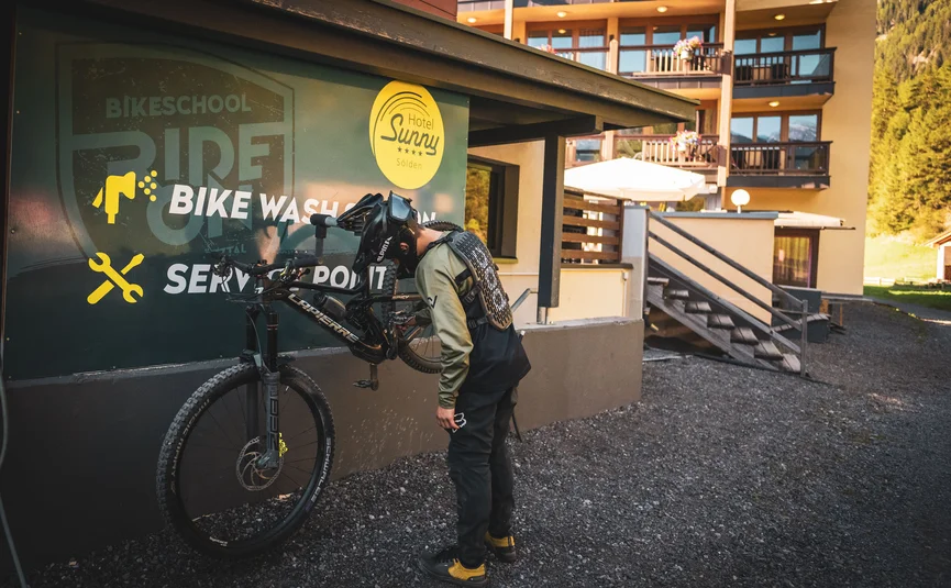 Cyclist inspecting bike at bike wash and service station