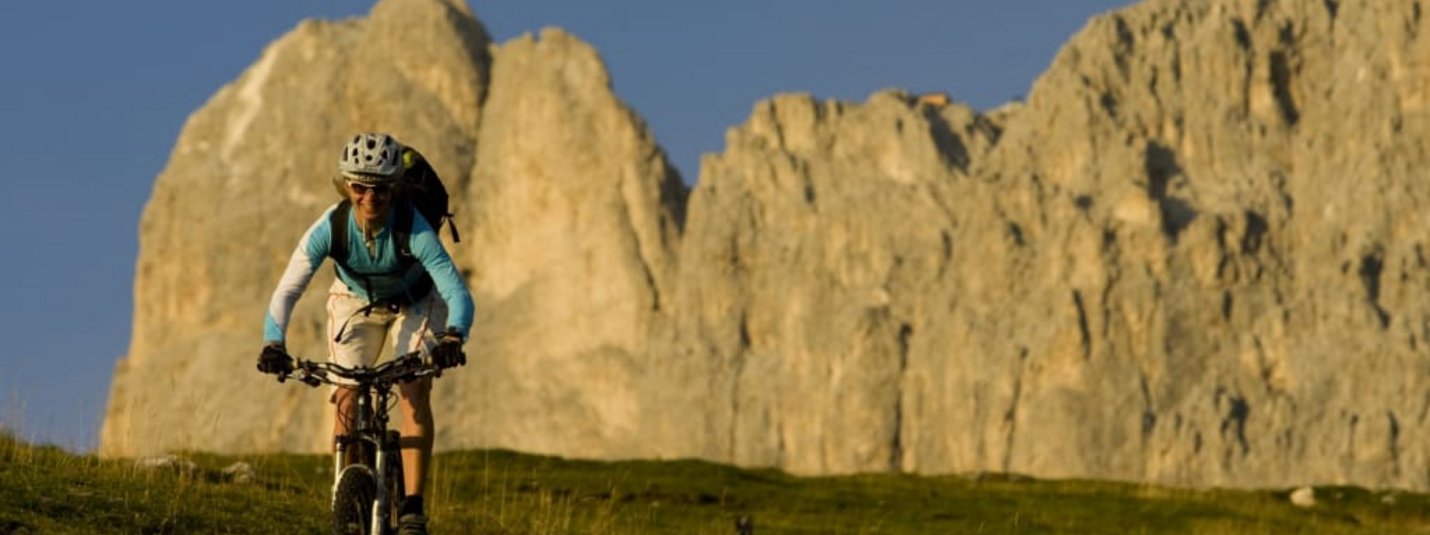 Familien Freeride Camp Frau fährt Mountainbike im Gebirge bei klarem Himmel