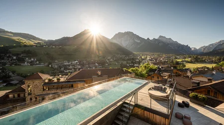 Rooftop infinity pool with mountain view at sunset