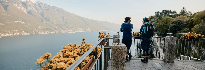 Unterwegs auf der Bond-Straße © Tobias Köhler Zwei Menschen auf Aussichtspunkt mit Blick auf See und Berge