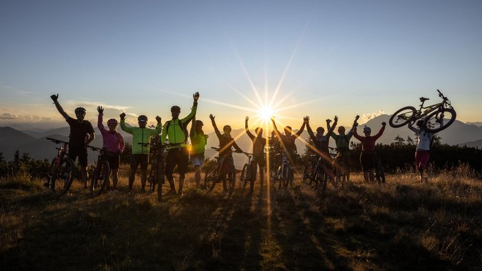 Fietsen als groep © Christian Huber Fotographie Groep fietsers die vieren bij zonsondergang op een berg