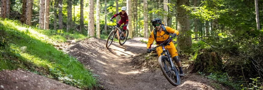 Saalbach Hinterglemm Leogang Fieberbrunn © Klemens König Two mountain bikers riding on a curvy forest trail with hills