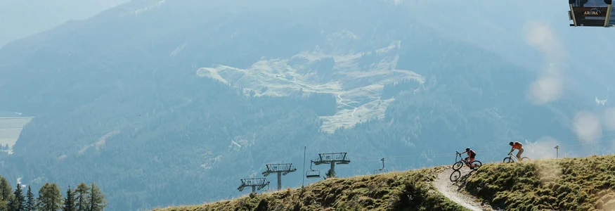7 gute Gründe für deinen Mountainbikeurlaub im Zillertal
© Felix Saller Zwei Fahrradfahrer auf einem Bergpfad mit Sessellift vor bewaldeten Bergen