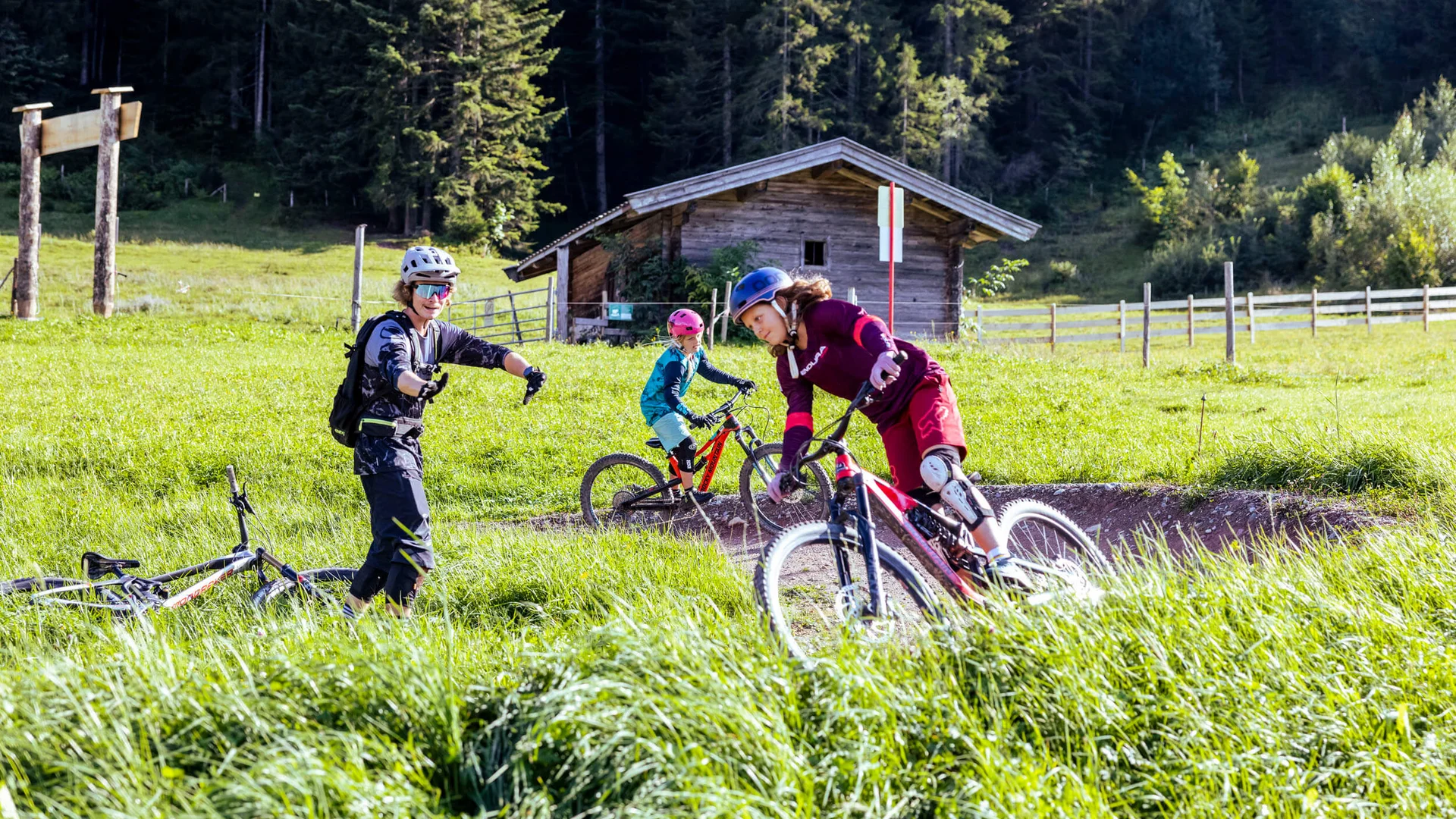 Kinder lernen Mountainbiken mit Helm in ländlicher Umgebung