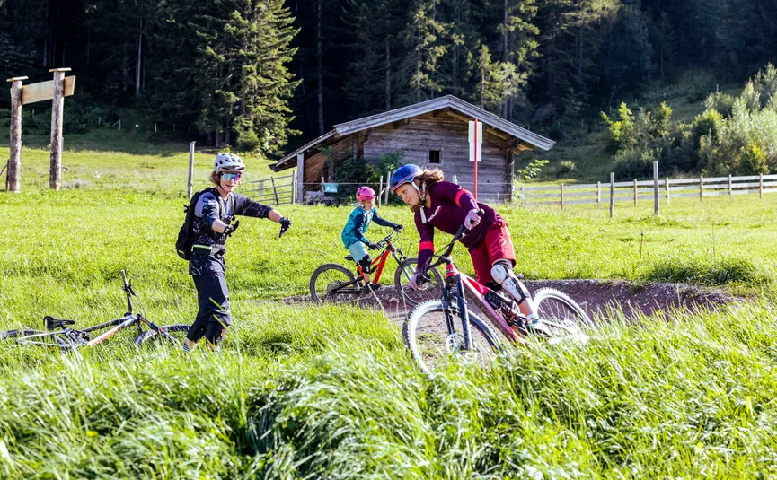 Kids learning mountain biking with helmets in rural setting